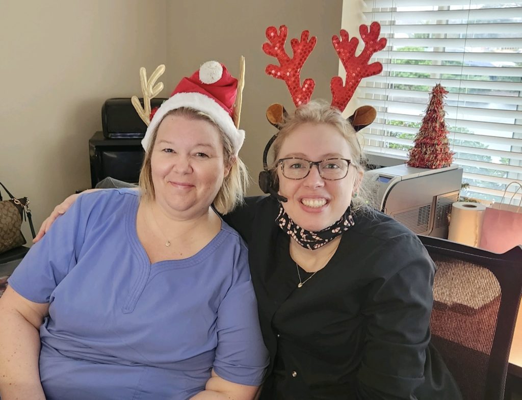 picture of team members sitting next to each other in the office with Christmas headbands.